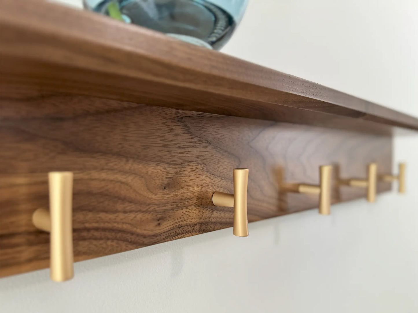 walnut wall mounted coat rack with shelf, champagne t hooks, close up view 