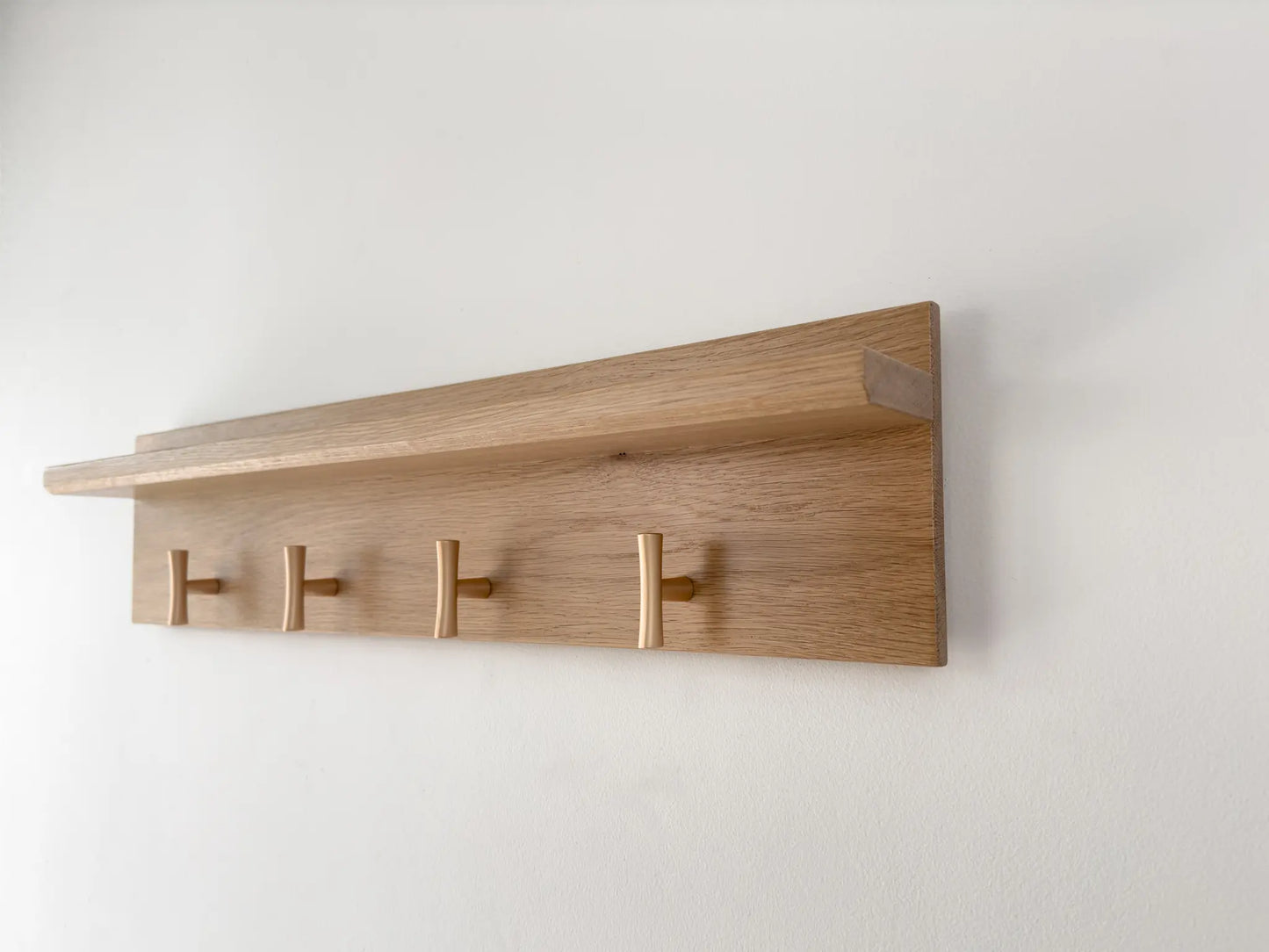 White oak coat rack and shelf, champagne t hooks, close up angled view 